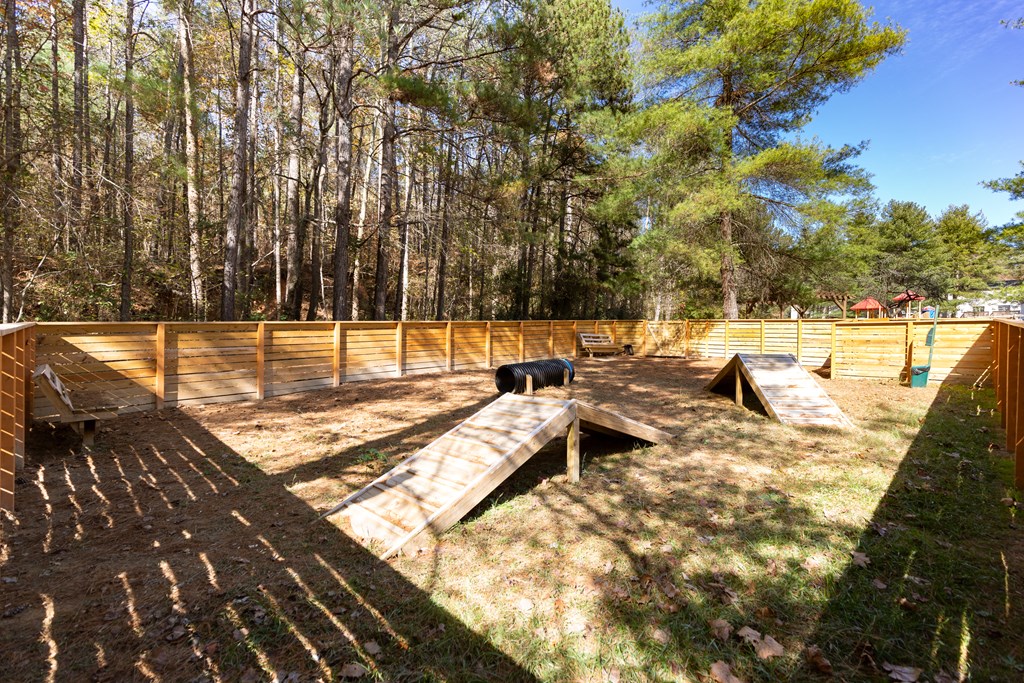 a cow in a fenced in area in the middle of a grassy area