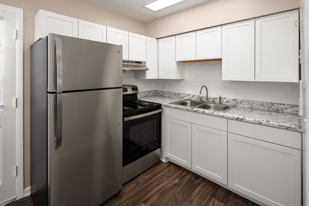 a kitchen with white cabinets and a stainless steel refrigerator