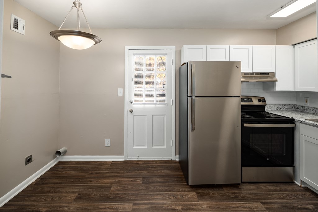 a kitchen with white cabinets and a stainless steel refrigerator