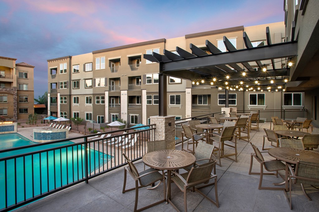 a patio with tables and chairs and a swimming pool