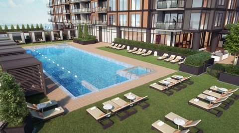 A large swimming pool surrounded by lounge chairs and trees.