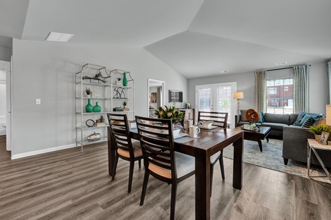 A modern dining room with a wooden table and chairs.