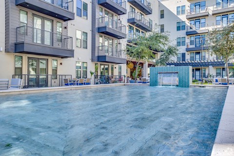 a swimming pool with an apartment building in the background