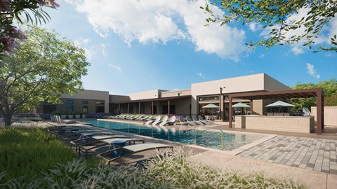 A large swimming pool with lounge chairs and umbrellas is surrounded by a building and greenery.