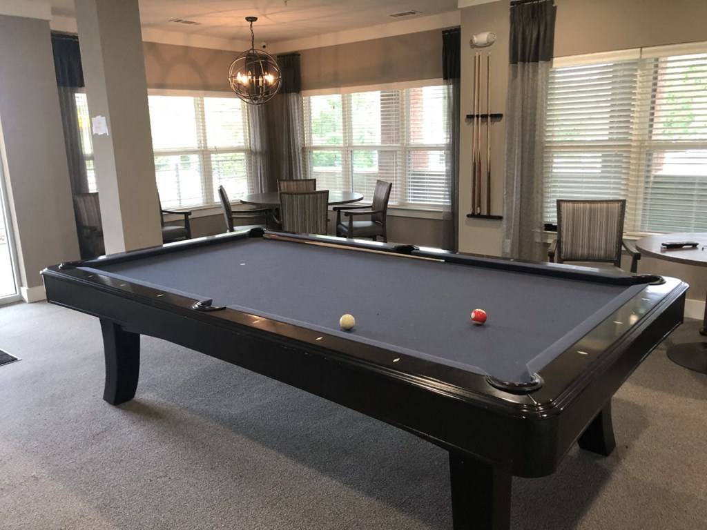 a pool table in a game room with a red ball on it