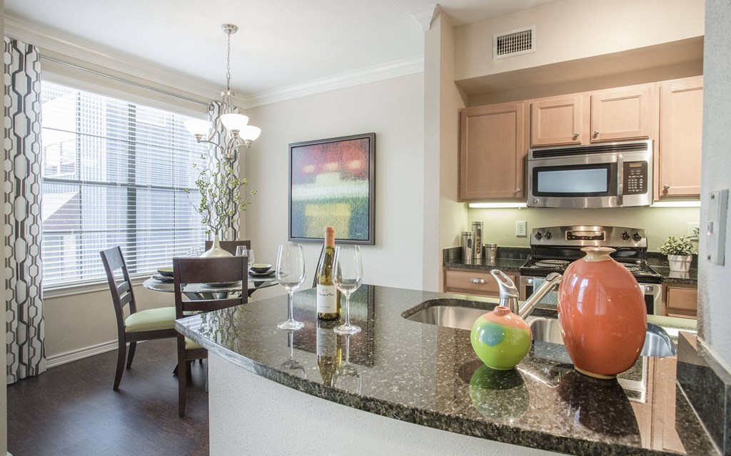 A kitchen with a granite counter top and a painting hanging on the wall.