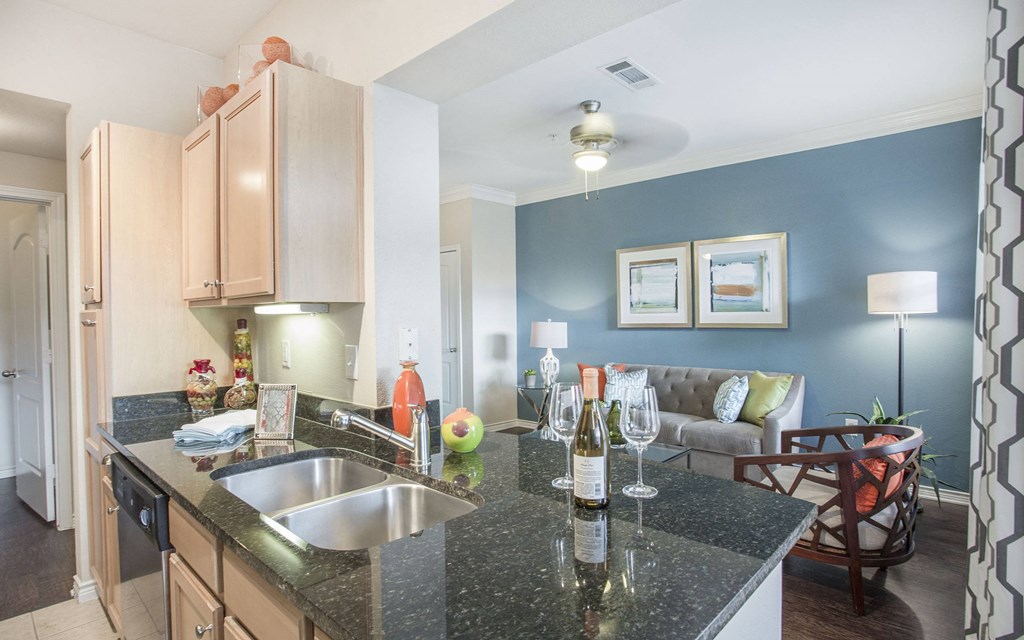 A kitchen with a sink, a counter, and a chair.
