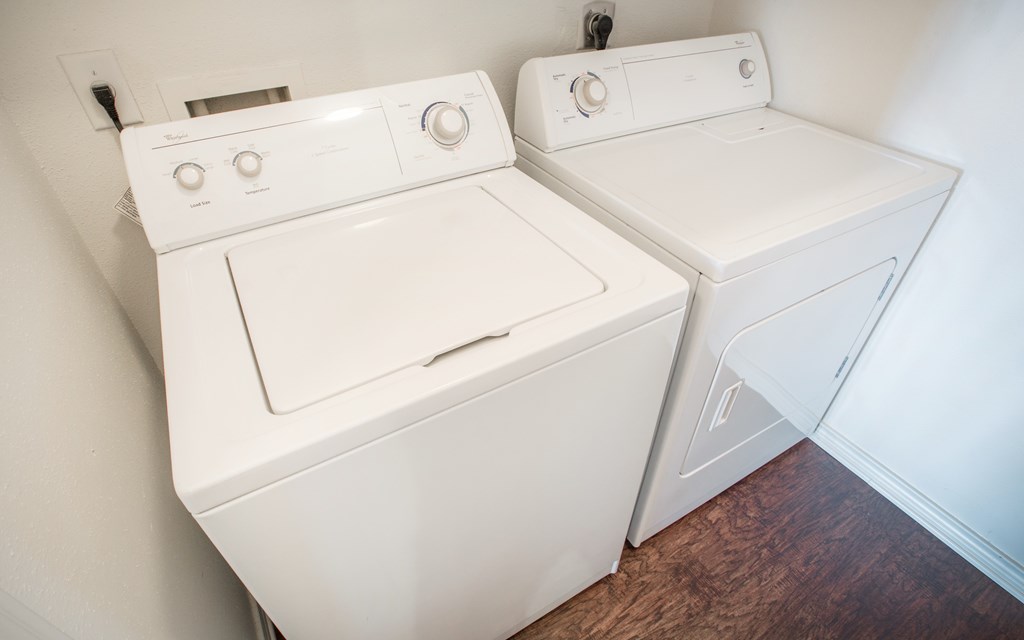 Two white washing machines in a small room.