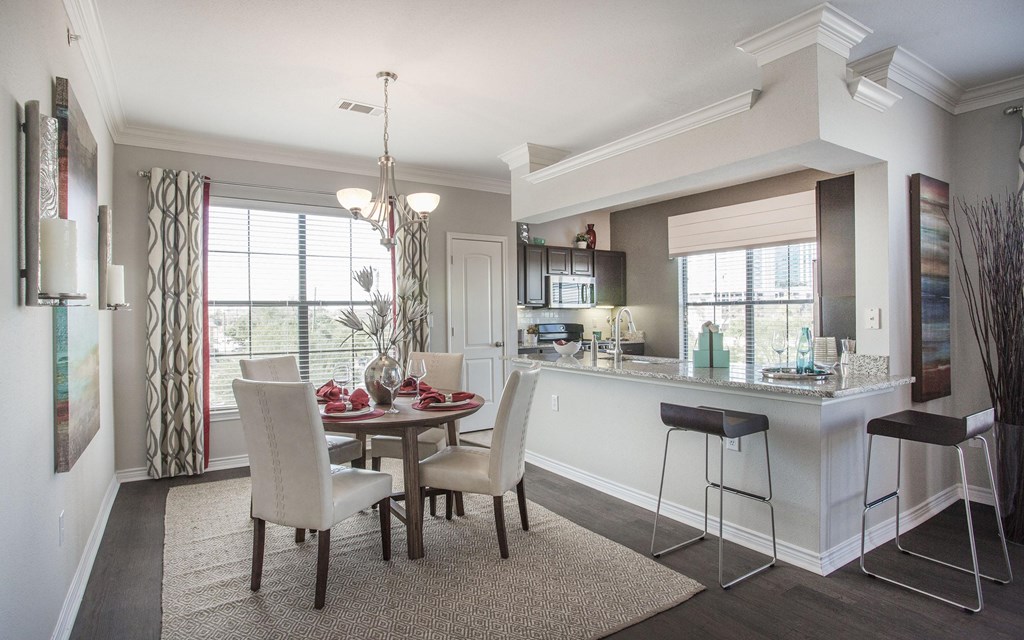 A dining room with a table set for two and a bar area.