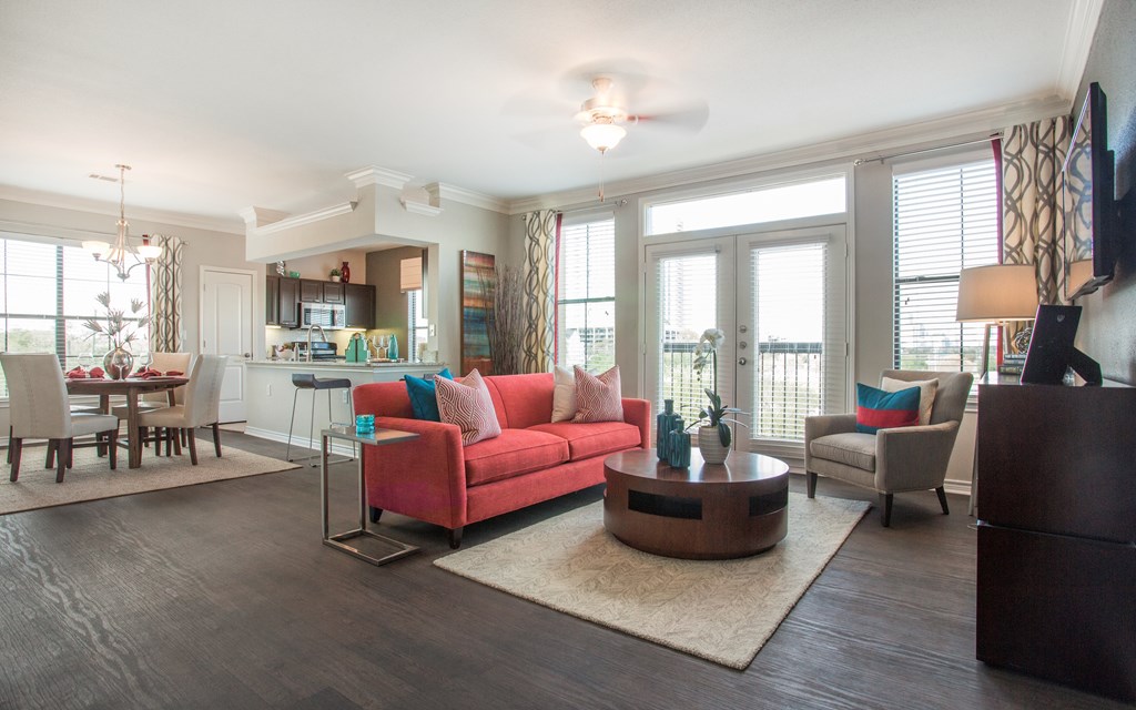 A living room with a red couch and a wooden coffee table.