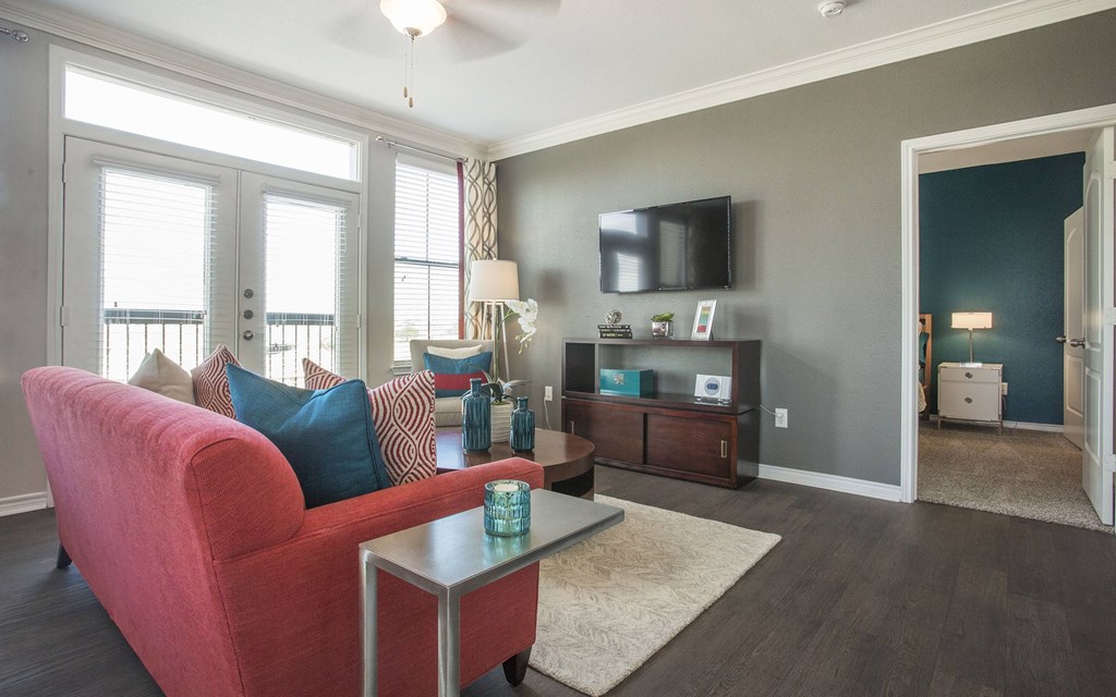 A living room with a red couch and a television.