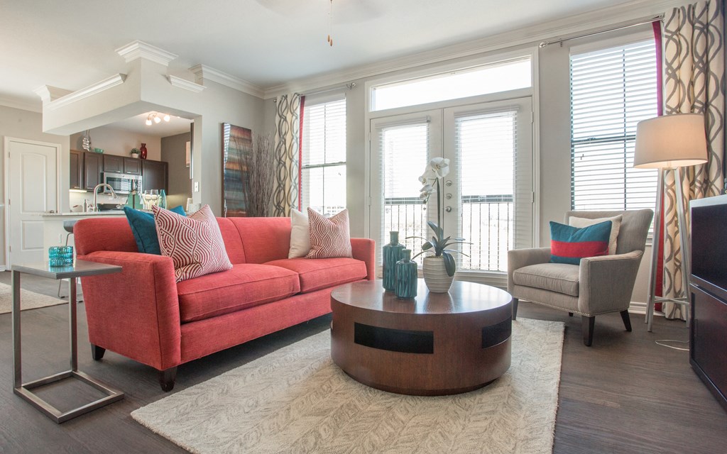 A living room with a red couch and a coffee table.
