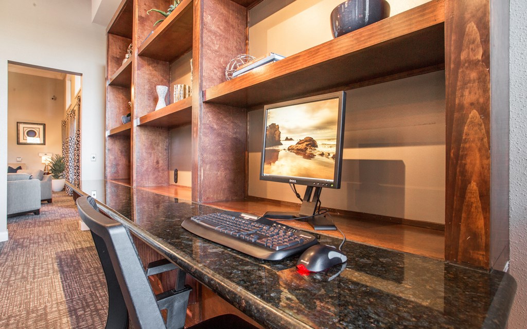 A modern home office with a large desk and a computer.