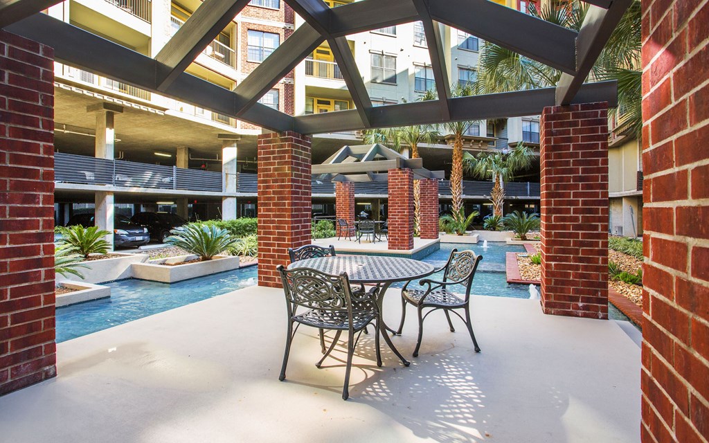 A patio with a table and chairs is covered by a roof.