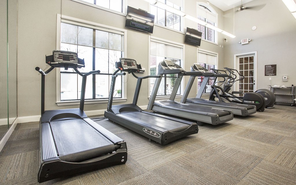 A gym with treadmills and elliptical machines.