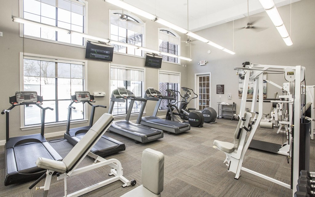 A gym with treadmills, elliptical machines, and other exercise equipment.