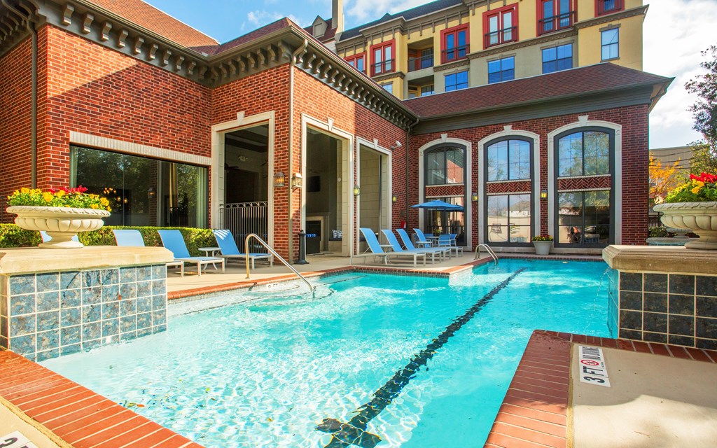 A pool surrounded by a brick building.