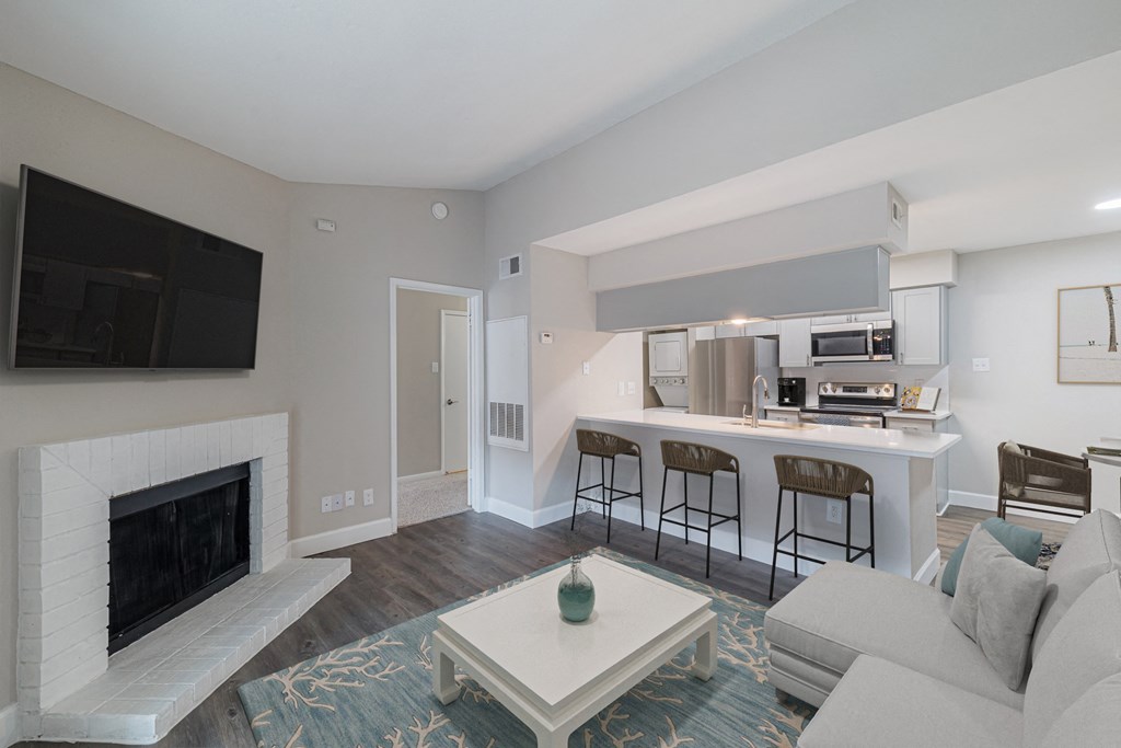 A living room with a fireplace and a bar area.