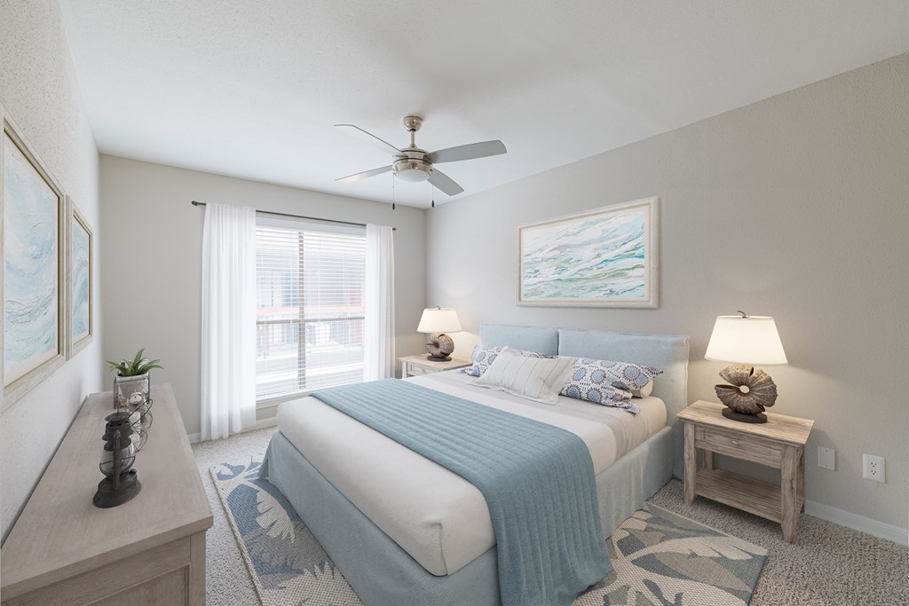 A bedroom with a bed, nightstand, and a ceiling fan.