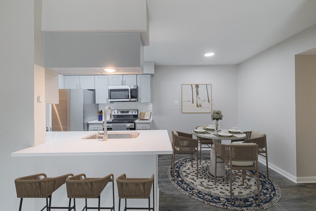A kitchen with a dining table and chairs.