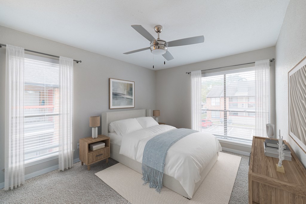 A bedroom with a bed, nightstand, and window.