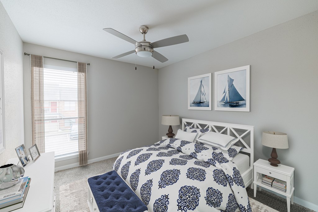 A bedroom with a bed, nightstand, and a ceiling fan.