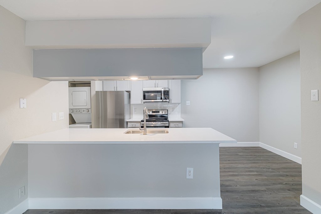 A modern kitchen with white cabinets and appliances.
