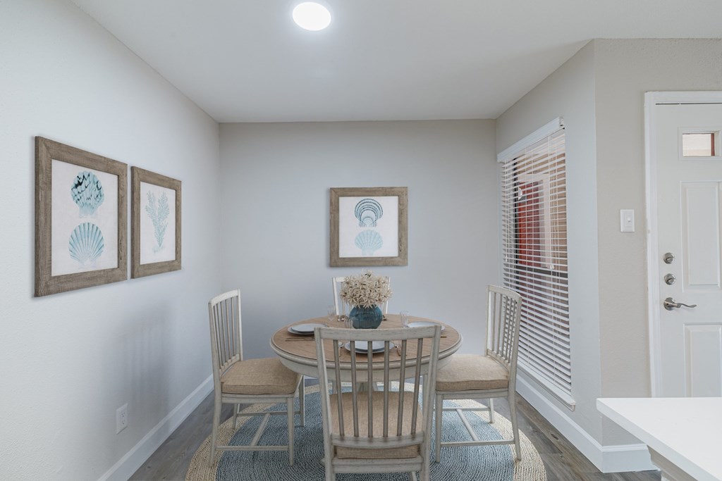A dining room with a table set for four.