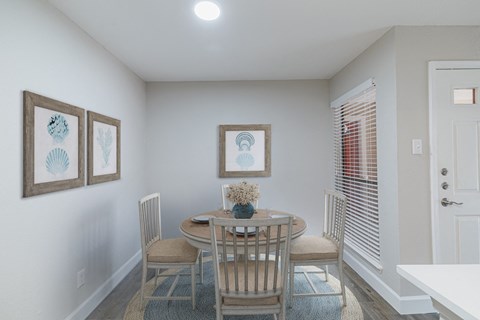 A dining room with a table set for four.