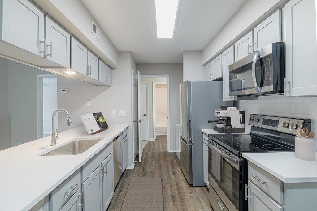 A kitchen with white cabinets and a black stove top oven.
