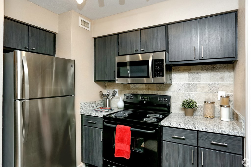 a kitchen with black appliances and stainless steel refrigerator