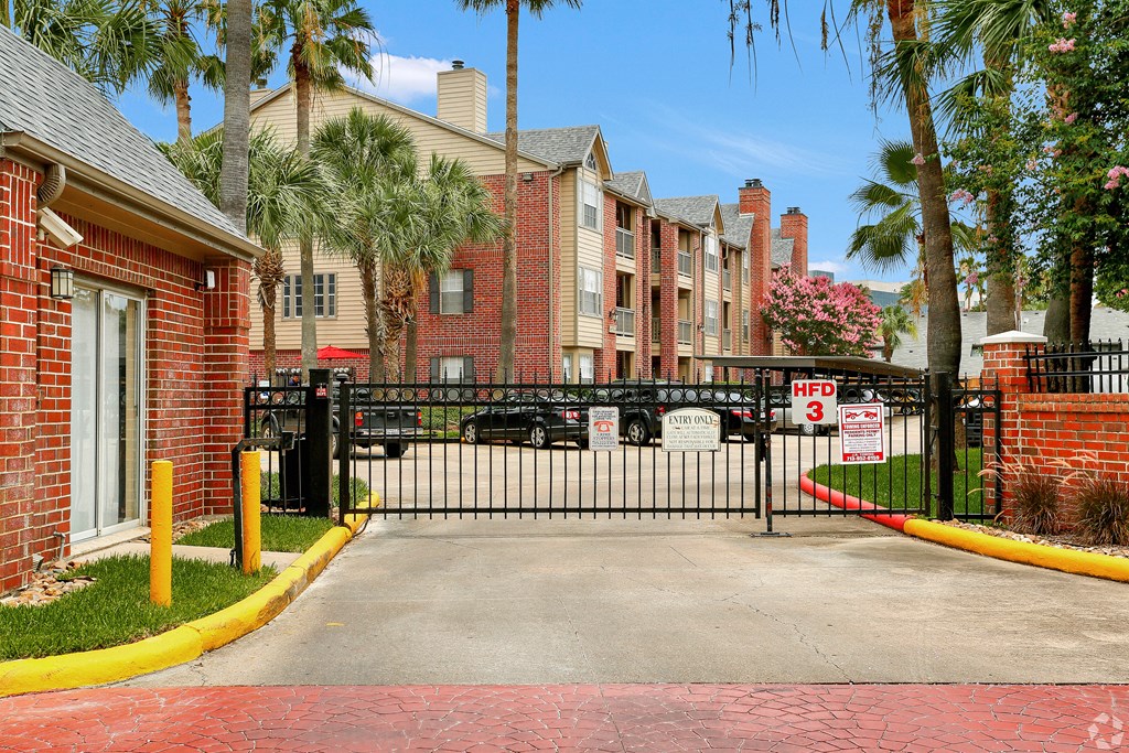 the gate to a parking lot in front of an apartment building