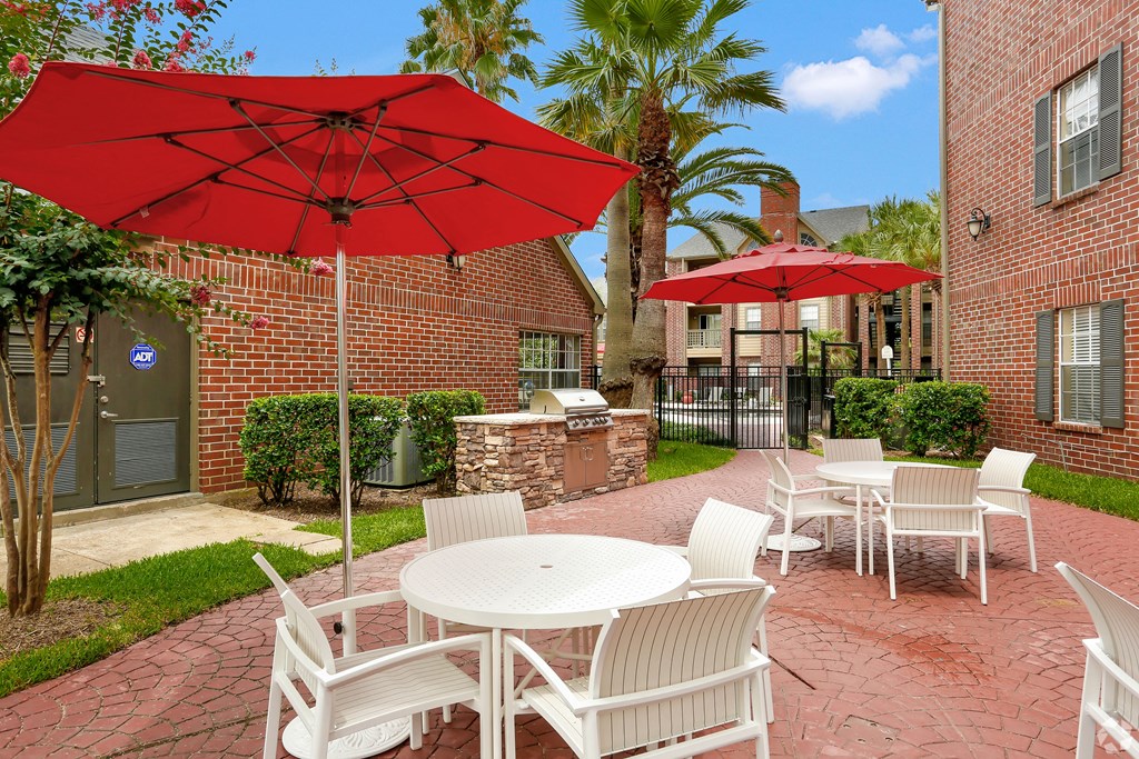 a patio with tables and chairs and umbrellas