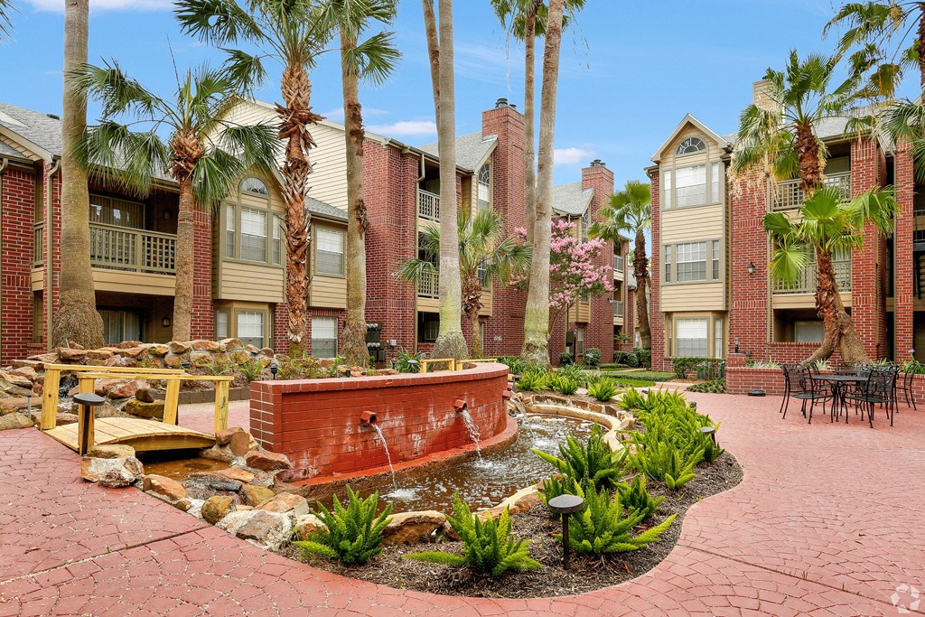 a courtyard with a fountain and palm trees