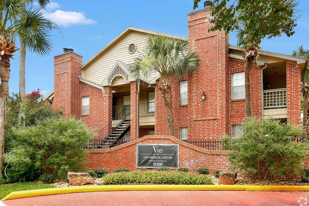 a large brick house with palm trees in front of it