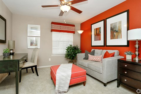 a living room with an orange accent wall and a couch