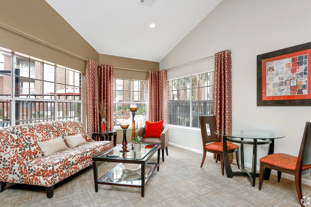 a living room with a couch and a table and windows