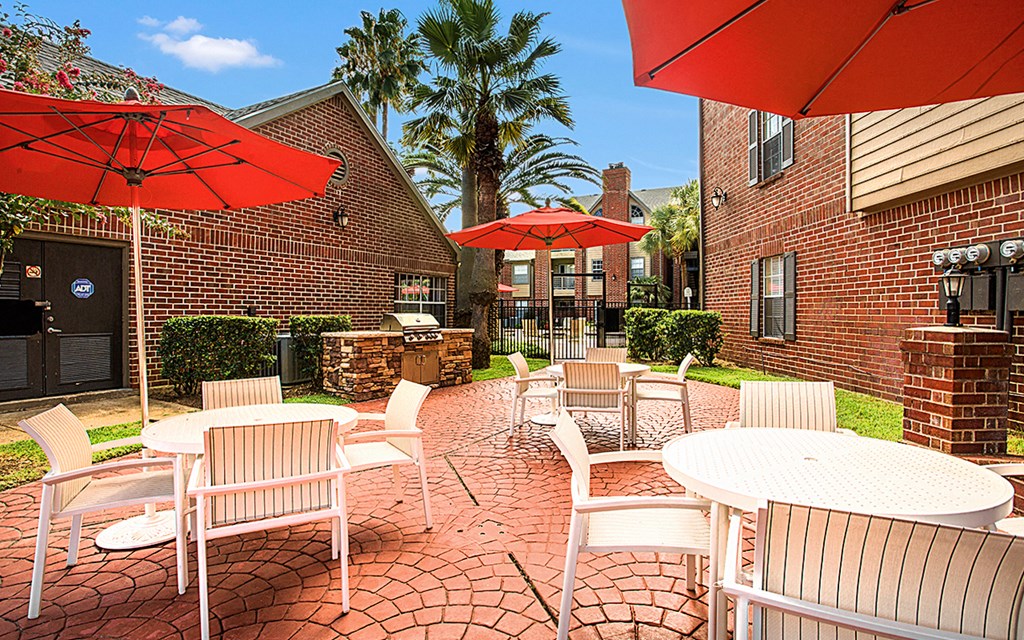 an outdoor patio with tables and chairs and umbrellas