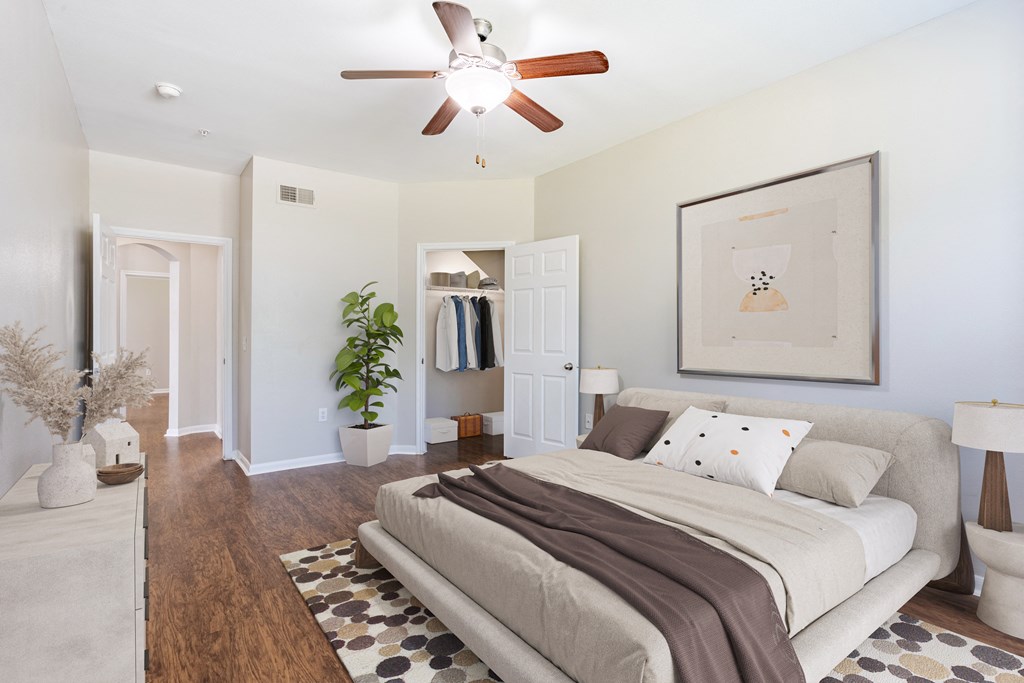 a bedroom with a large bed and a ceiling fan