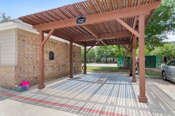 a covered parking lot in front of a brick building