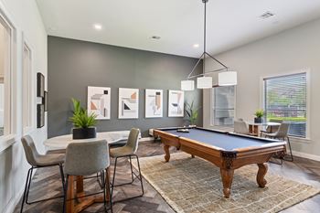 an open living room with a pool table and a dining table