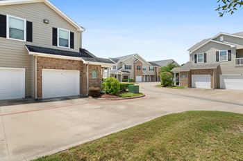 an empty driveway in front of a row of houses