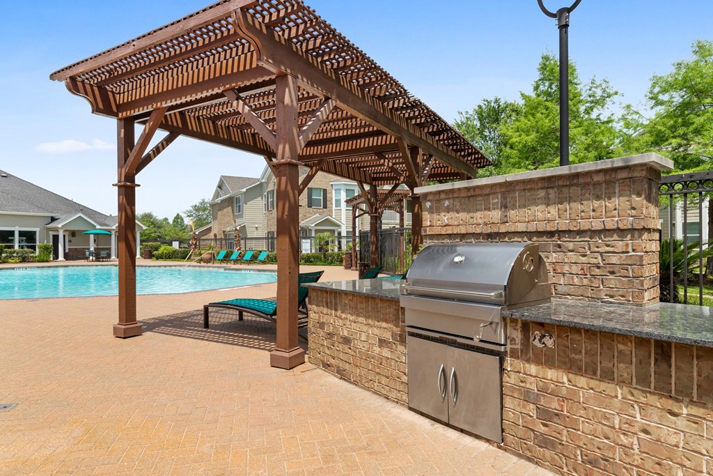 an outdoor kitchen with a grill and cabana area