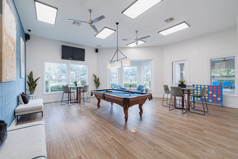 A room with a pool table and a television.
