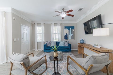 A living room with a blue couch and two chairs.