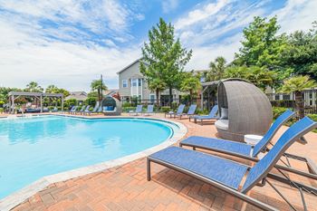 A pool with a blue lounge chair in the foreground.