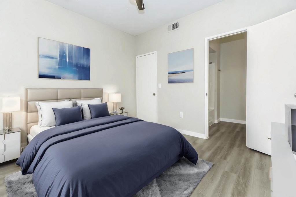 a bedroom with a large bed and a door to a bathroom