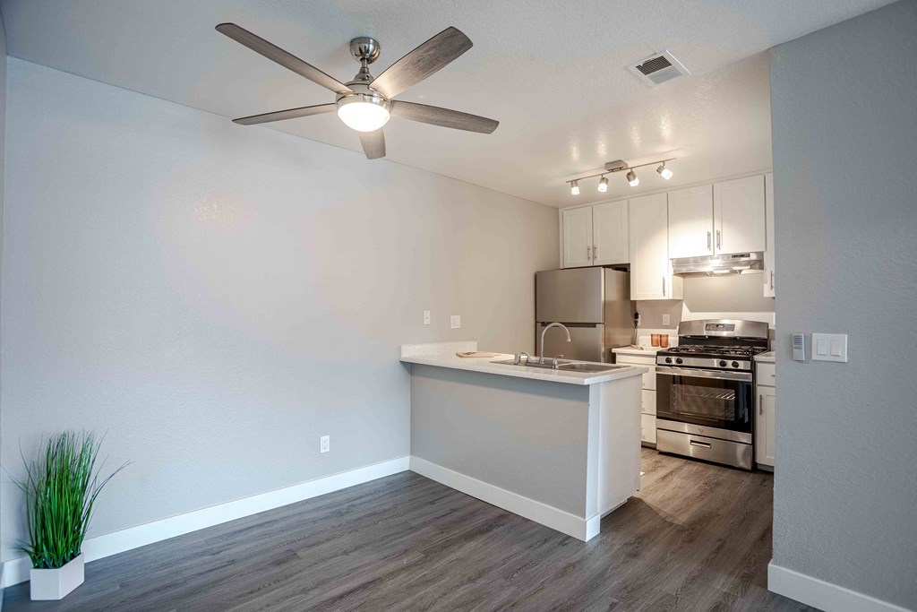 an open kitchen and living room with a ceiling fan