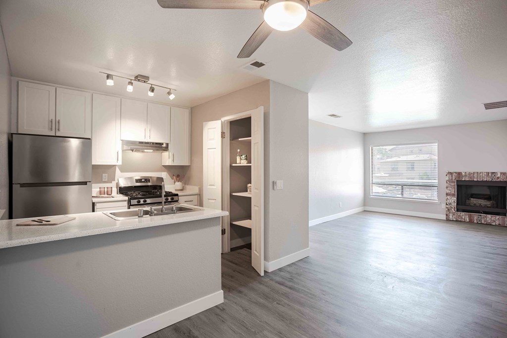 an open kitchen and living room with a ceiling fan