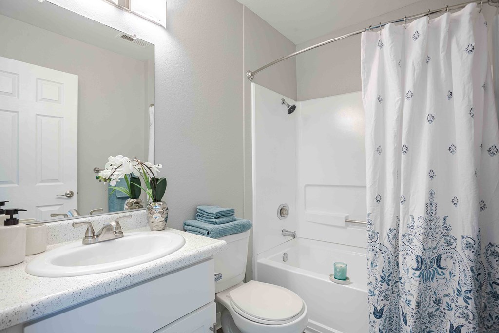a white bathroom with a shower and a sink and a toilet